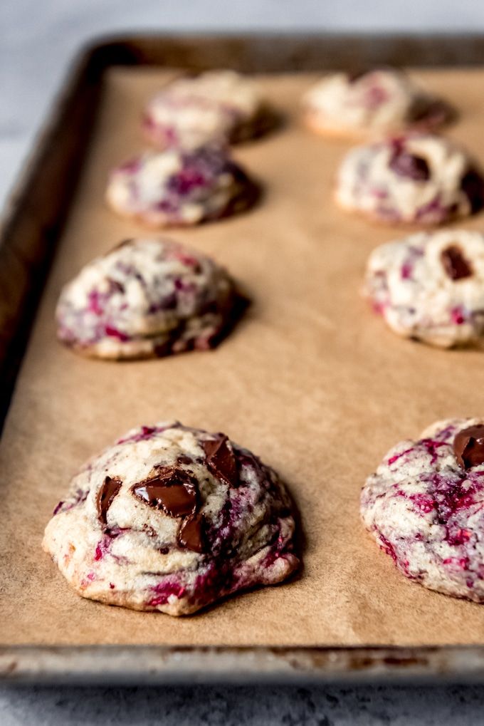 chocolate chip cookies with raspberry filling on a cookie sheet ready to be baked