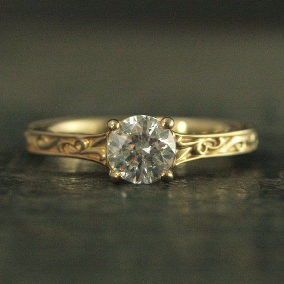 a gold engagement ring with a diamond in the center