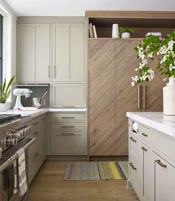 a kitchen with white cabinets and wood flooring on the walls is pictured in this image