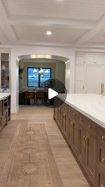 a large kitchen with wooden cabinets and white counter tops, along with an area rug on the floor