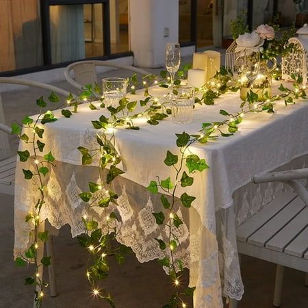 the table is covered with greenery and lit candles