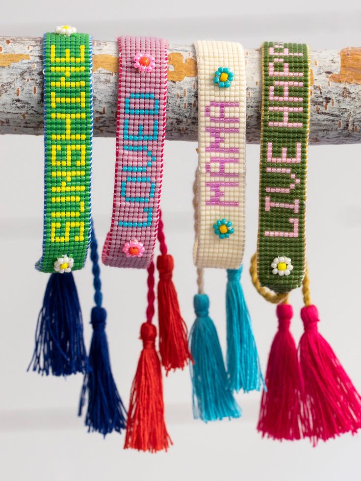 colorful bracelets hanging from a tree branch with the words happy birthday written on them