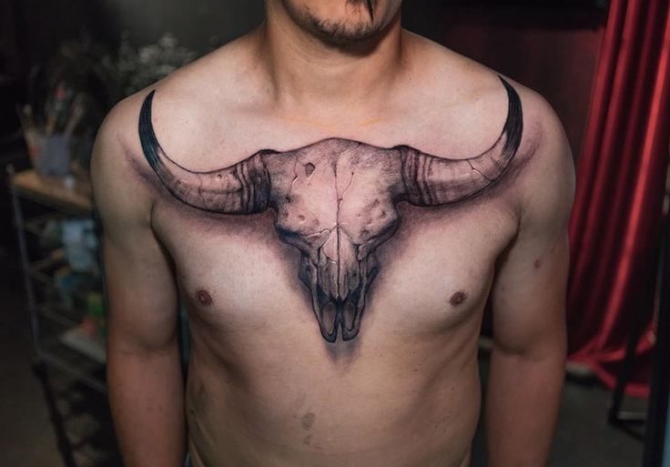 a man with a bull's head tattoo on his chest