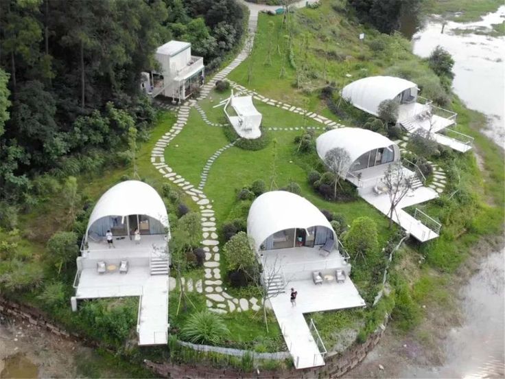 an aerial view of some houses in the middle of a green area with stairs leading up to them