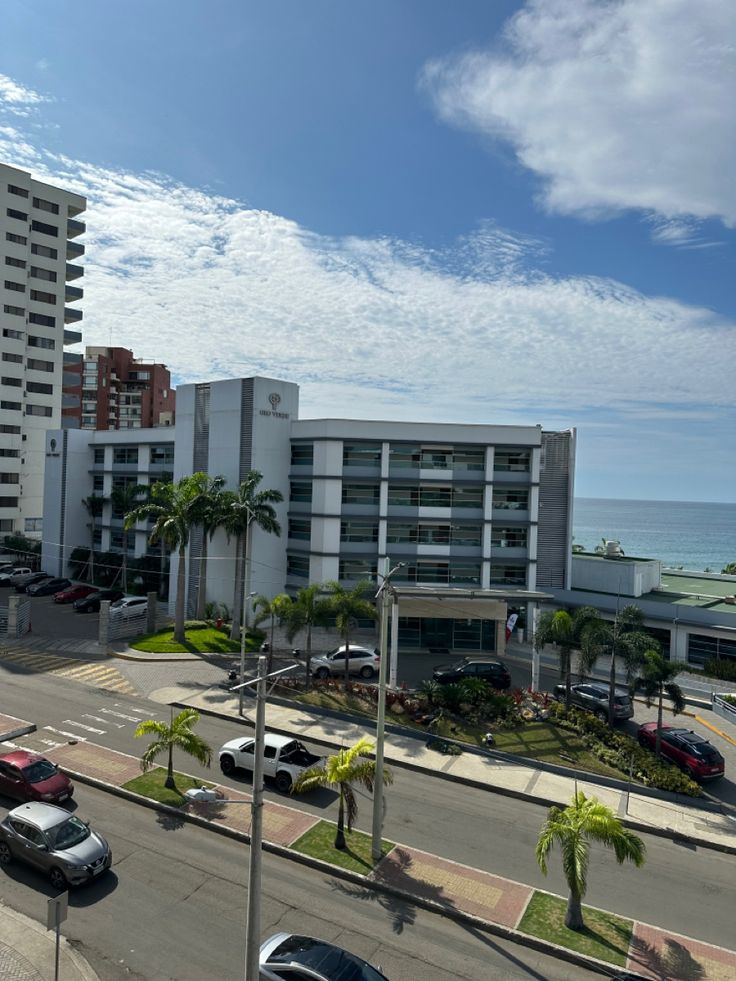 cars are parked on the side of an empty street near buildings and beachfronts