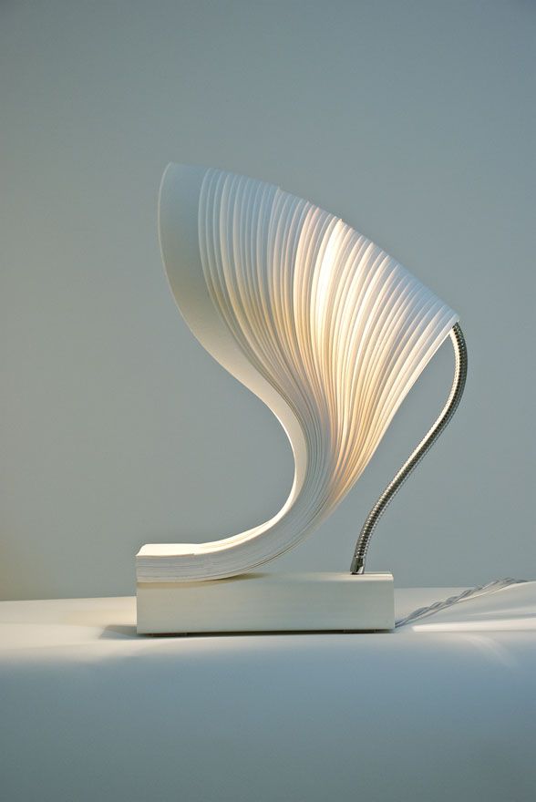 a white sculpture is sitting on top of a table and it looks like an abstract piece of art