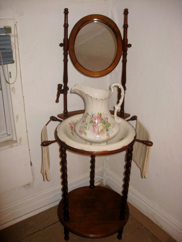 a table with a mirror and vase on it