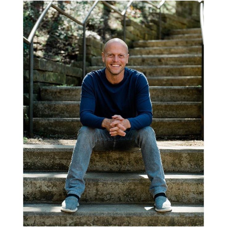 a man sitting on the steps in front of some stairs