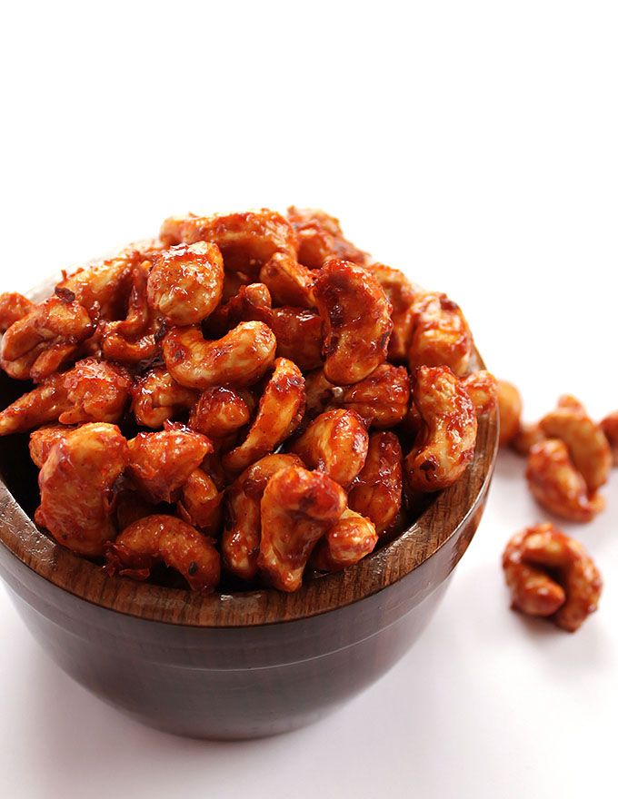 a wooden bowl filled with nuts on top of a white table