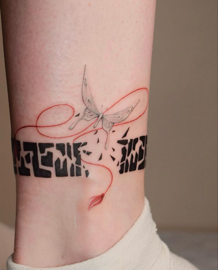 a woman's foot with a tattoo on the ankle that has words and a butterfly