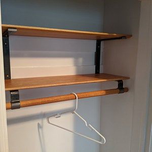 an empty closet with some shelves and clothes hangers