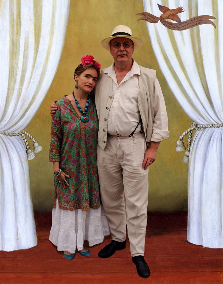 a man and woman standing next to each other in front of white drapes with birds on them