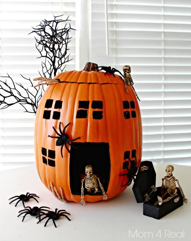 an orange pumpkin decorated with skeletons and spider webs, sitting on top of a white table