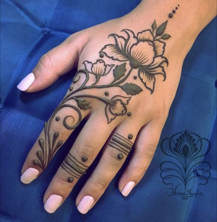 a woman's hand with a flower tattoo on it