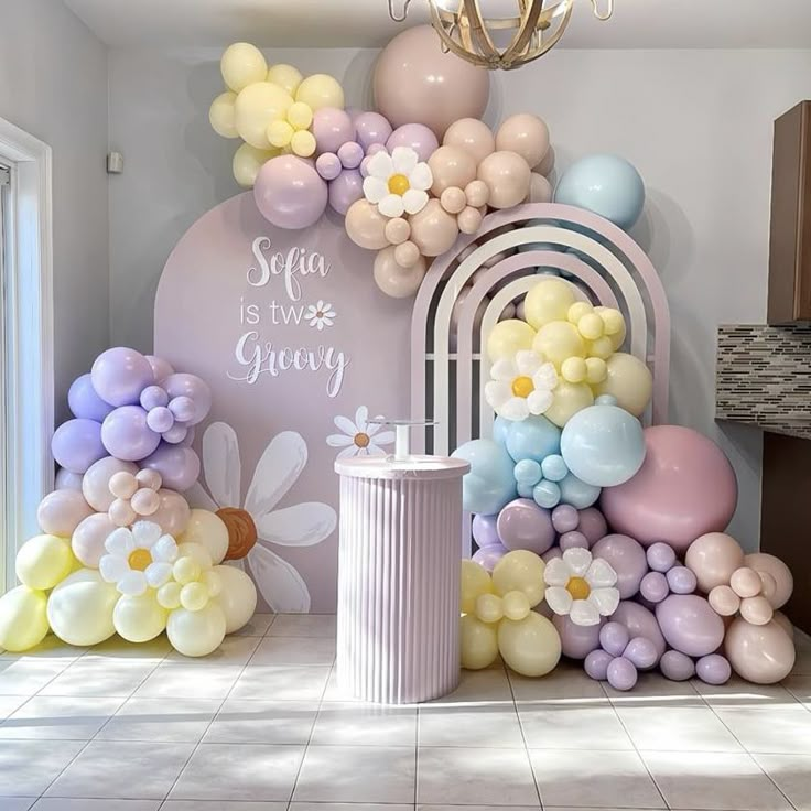 a room with balloons and flowers on the wall