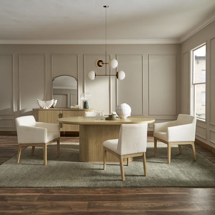 a dining room table with white chairs and a large mirror on the wall behind it