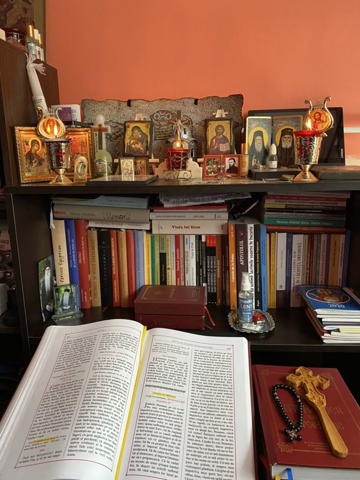 an open book sitting on top of a table next to a shelf filled with books