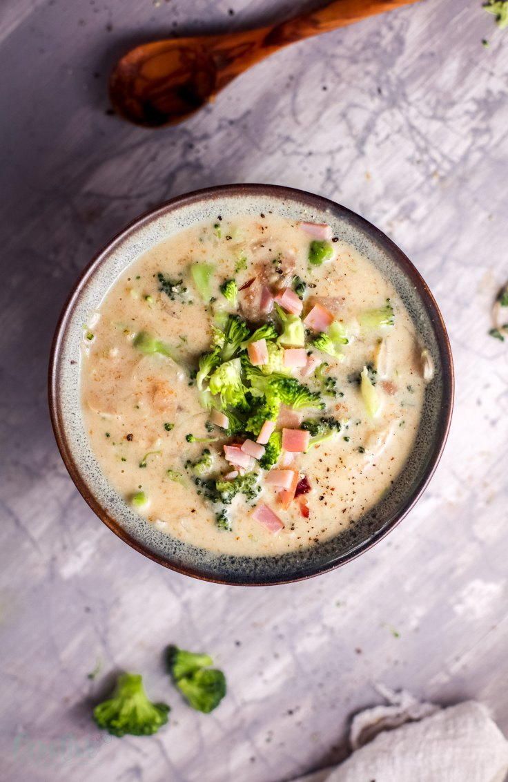 a bowl filled with broccoli soup on top of a table