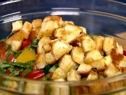 a glass bowl filled with salad and croutons