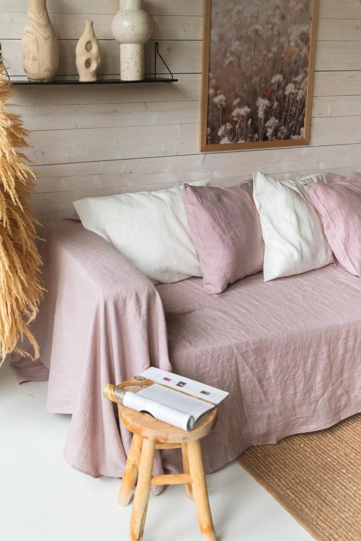 a living room filled with furniture and lots of pillows on top of it's covers