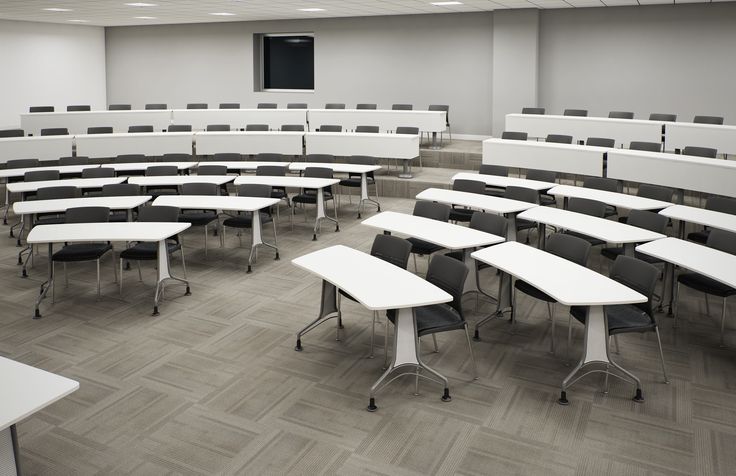 an empty classroom with desks and chairs in the middle is seen from across the room