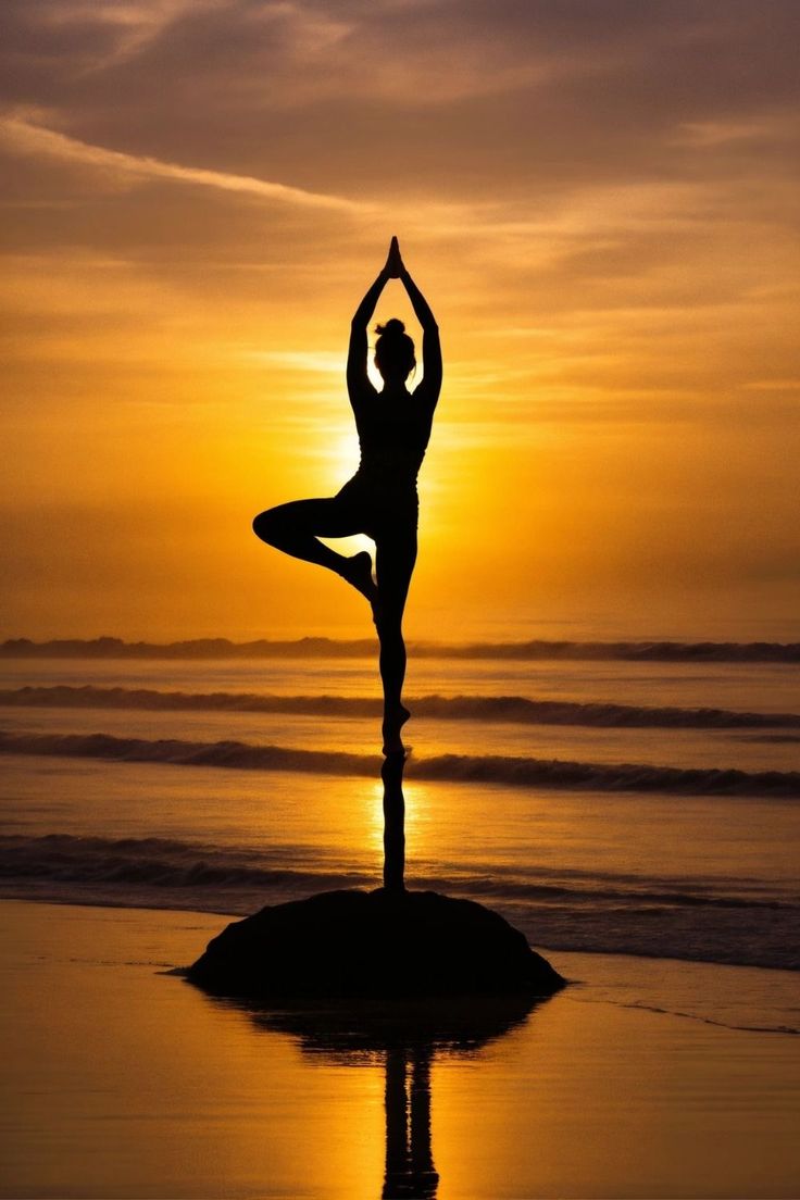 a person doing yoga on the beach at sunset