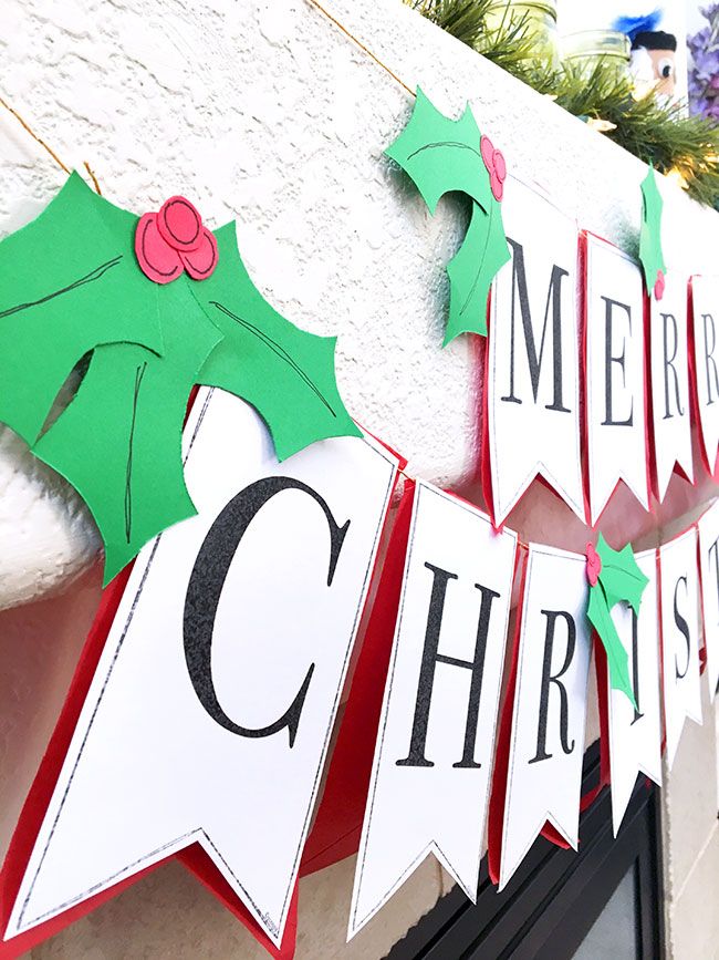 a christmas banner hanging from the side of a building with decorations on it's sides