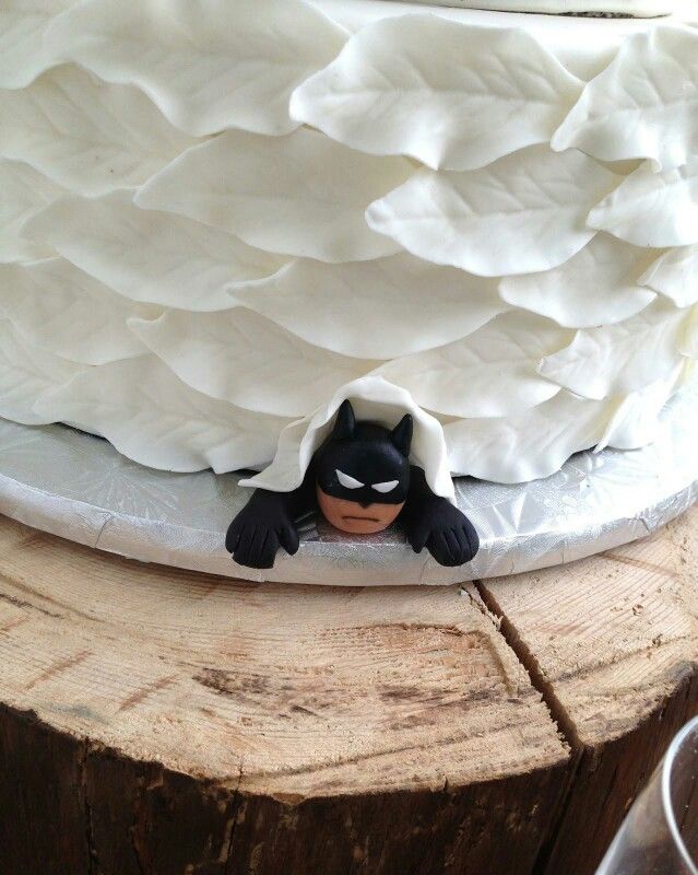 a cake with white frosting and a batman figure on top