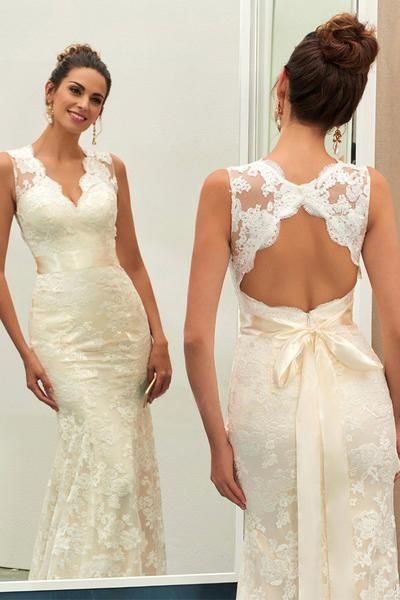 the back of a woman's wedding dress in front of a mirror with her reflection