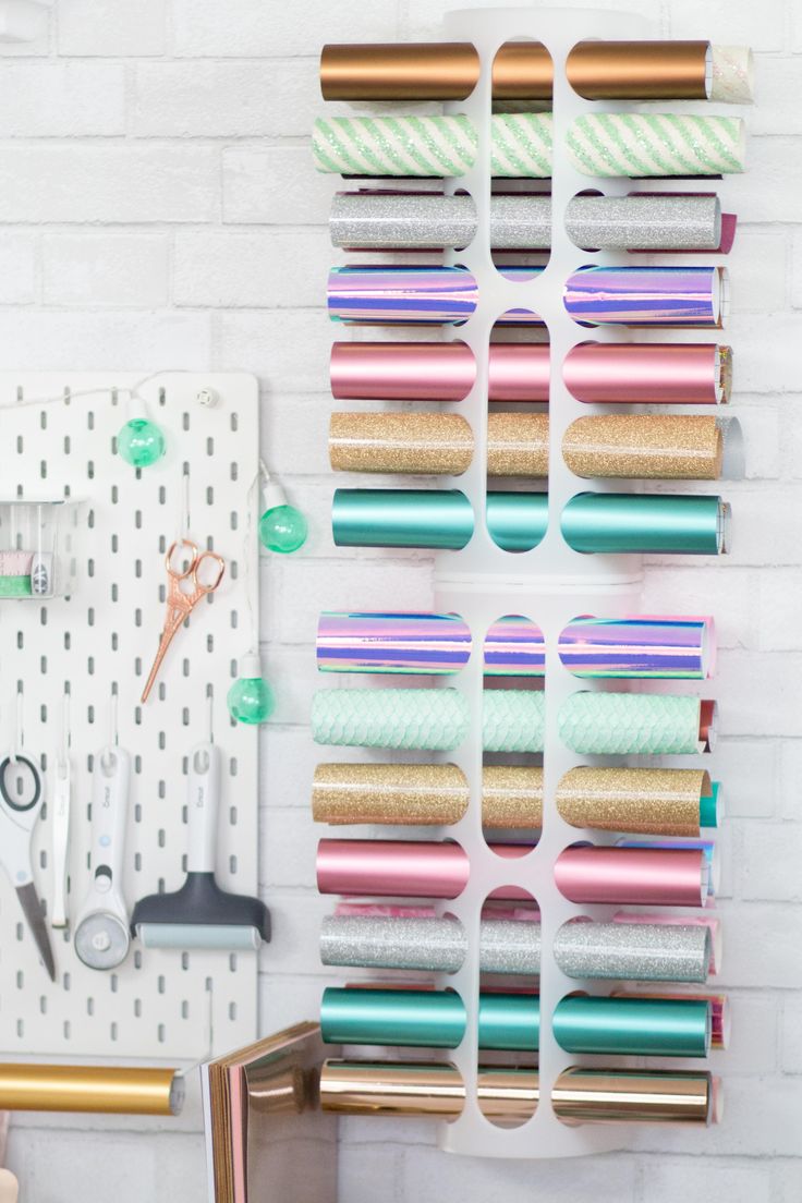 several rolls of tape are hanging on a wall next to scissors and other crafting supplies