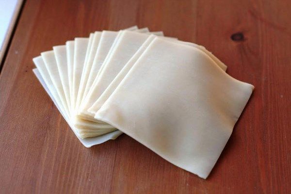 six folded napkins sitting on top of a wooden table