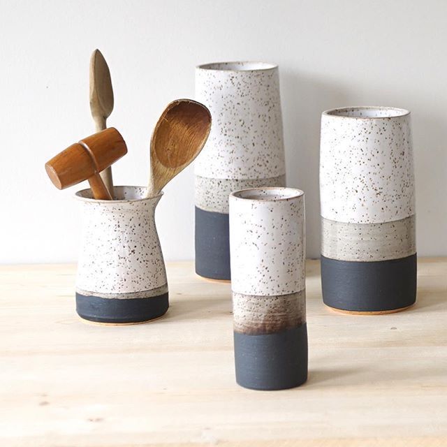 four ceramic cups with wooden spoons in them