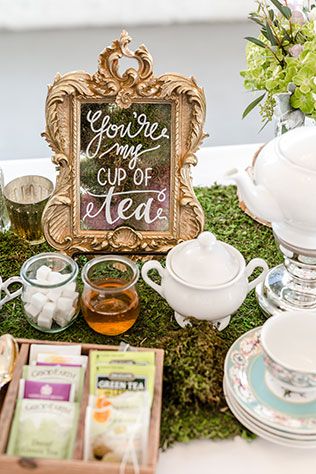 a table topped with plates and cups filled with different types of tea next to a sign that says you're my cup of tea