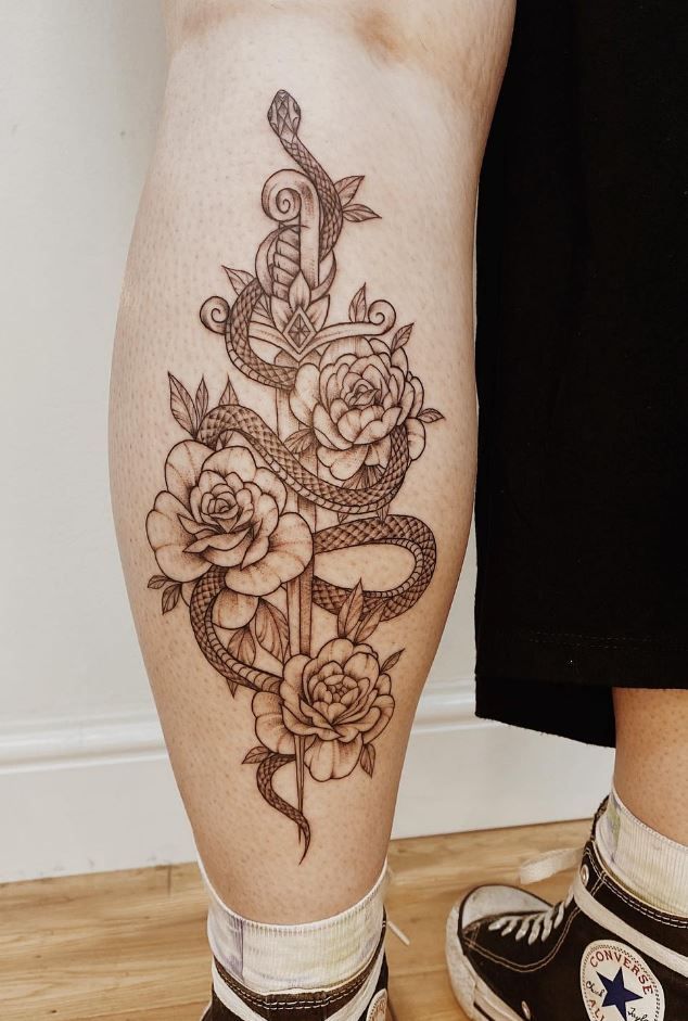 a woman's legs with tattoos and flowers on them