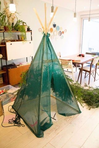 a teepee tent sitting on top of a hard wood floor next to a table