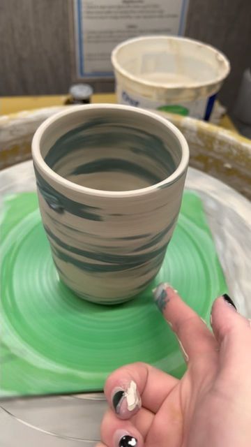 a woman's hand is on the edge of a pottery bowl