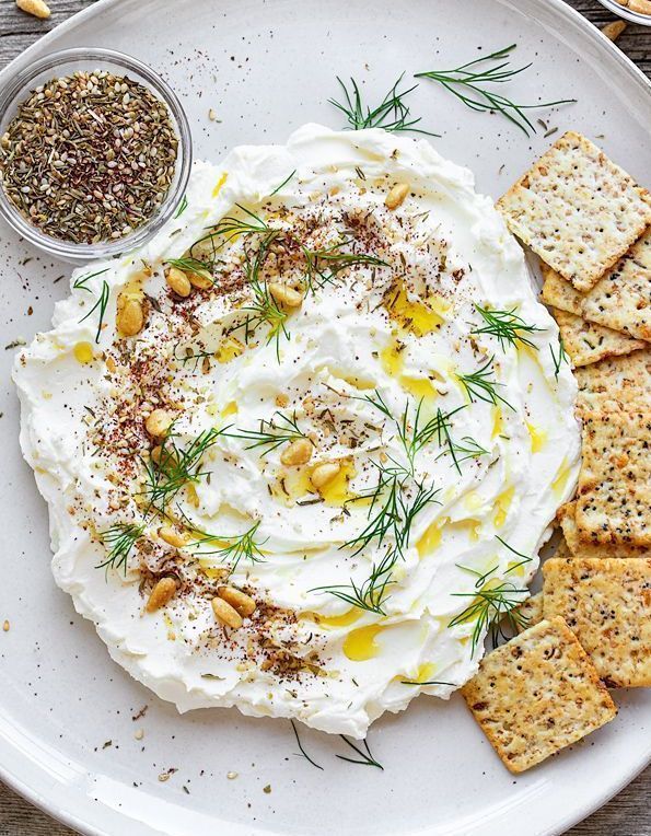 a plate with crackers and hummus on it