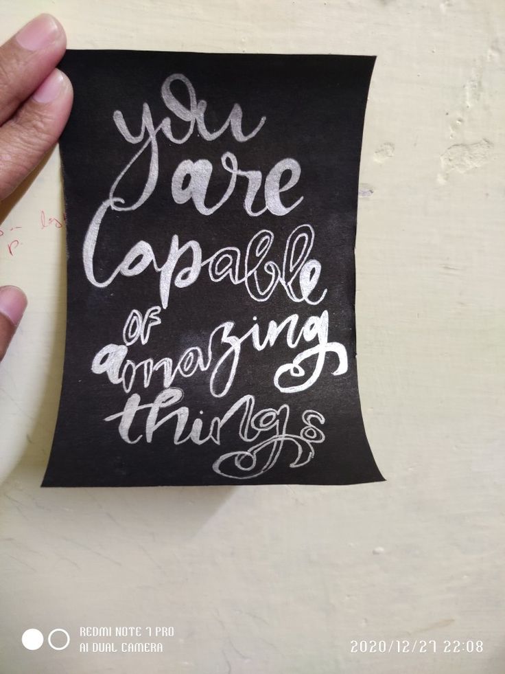 someone holding up a piece of paper with writing on it that says you are capable of amazing things