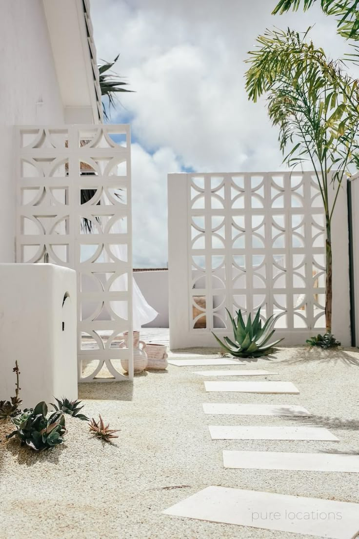 an outdoor area with white walls and plants