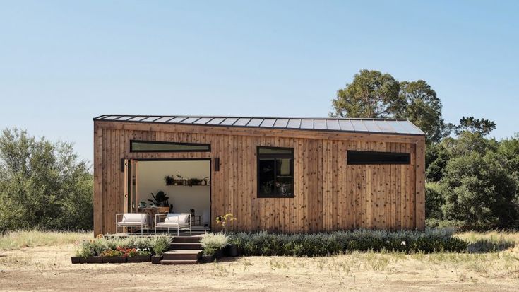 a small wooden house in the middle of a field