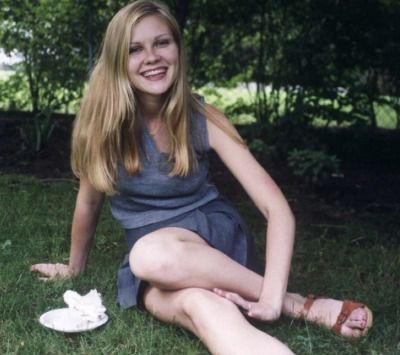 a woman sitting in the grass with her legs crossed