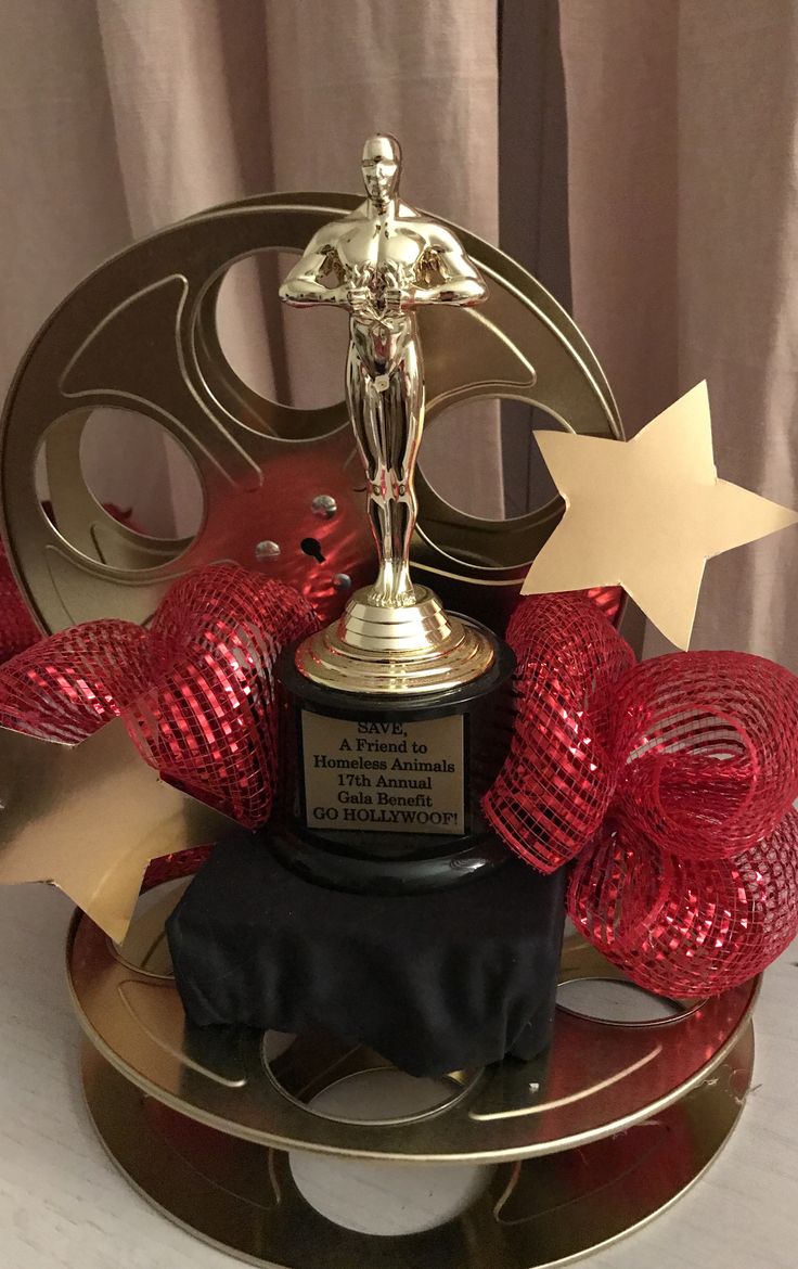 an award is placed on top of a table with red ribbon and gold star decorations