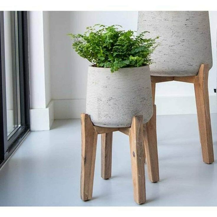 two planters sitting on top of wooden legs