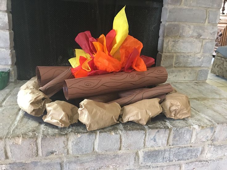 a fire place with paper wrapped around it and some logs on the fireplace mantel