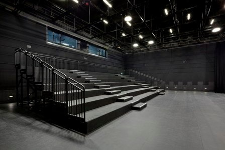 an empty room with stairs and lights on the ceiling is lit by spotlights from above