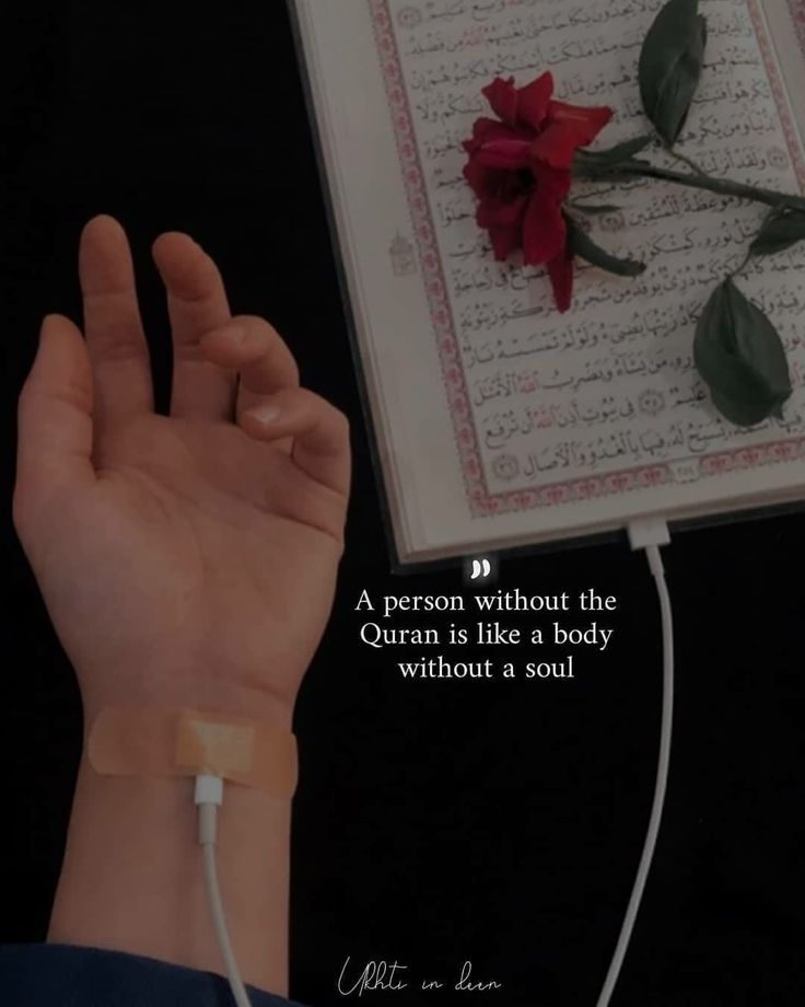 a person holding their hand in front of a book with a rose on it and an arabic quote