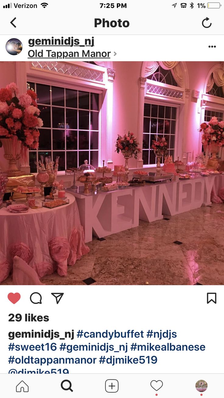 the table is set up with pink flowers and desserts on it for an event