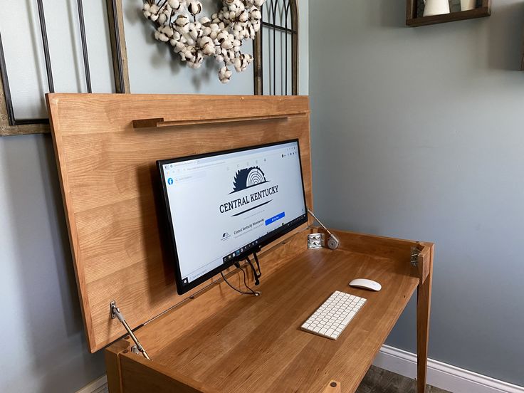 a computer monitor sitting on top of a wooden desk