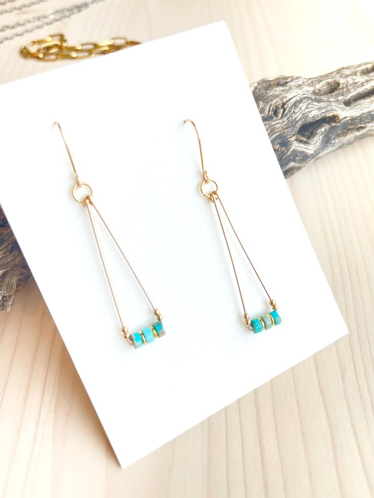 Beautiful 14K Gold Filled wire triangle drops with rich Turquoise gemstones and solid gold accent beads. They measure approximately 2.25 inches from the top of the ear wire.These are lightweight, fun and perfect for everyday. All of our handcrafted items arrive wrapped, perfect for gift giving!Made in the USA. Bead Wrapped Earrings, Minimalist Jewelry Making, Geometric Wire Earrings, Simple Beaded Jewelry Ideas, Simple Wire Wrapped Jewelry, Simple Metal Earrings, Boho Beaded Jewelry, Gemstone Earrings Handmade, Made Jewelry Ideas