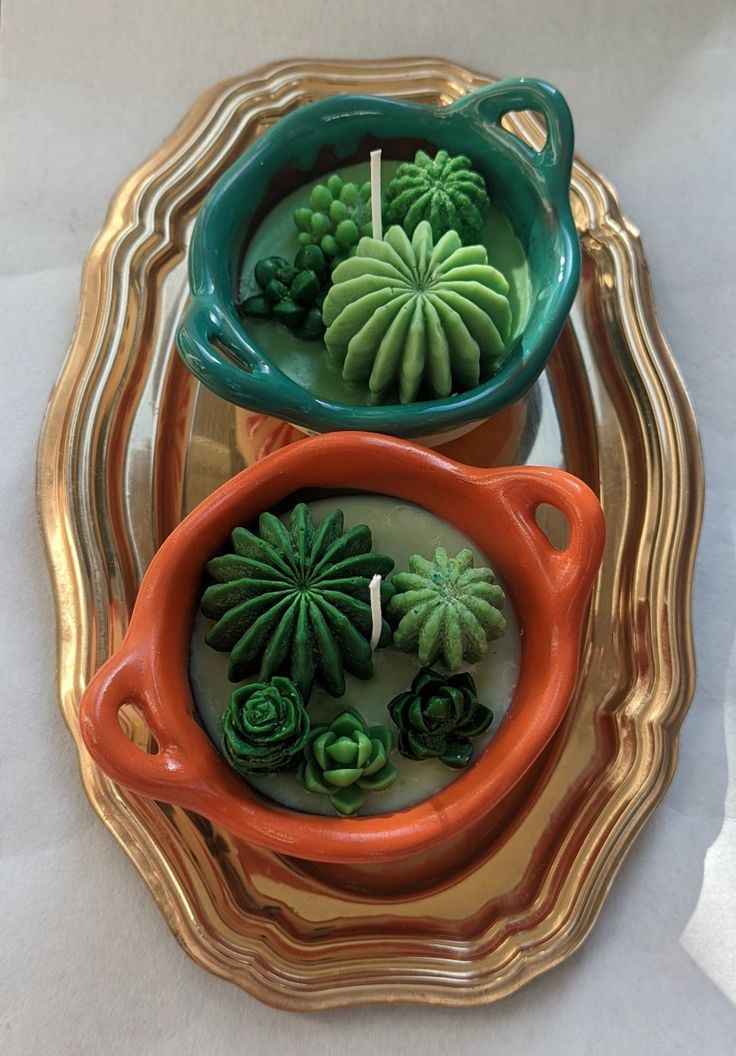 two orange and green planters sitting on top of a plate